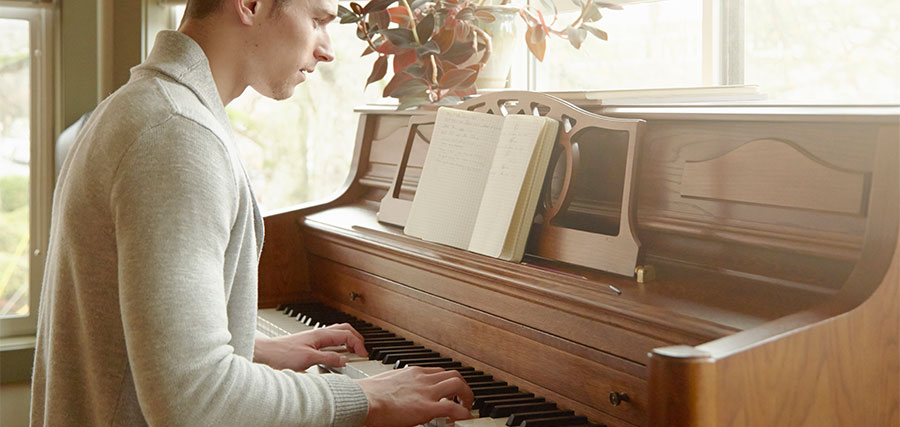Junger erwachsener Mann spielt Klavier