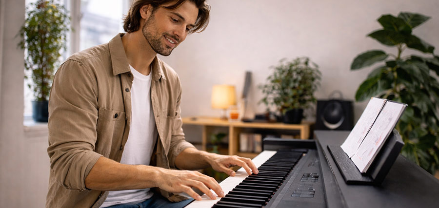 Mann spielt zu Hause auf einem Digitalpiano
