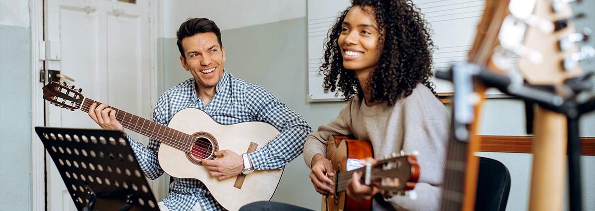 Zwei Erwachsene spielen Gitarre