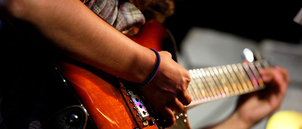 Nahaufnahme eines Gitarristen beim Spielen einer elektrischen Gitarre