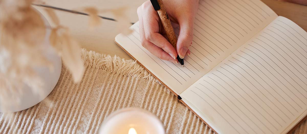 Eine Hand, die in ein Notizbuch schreibt