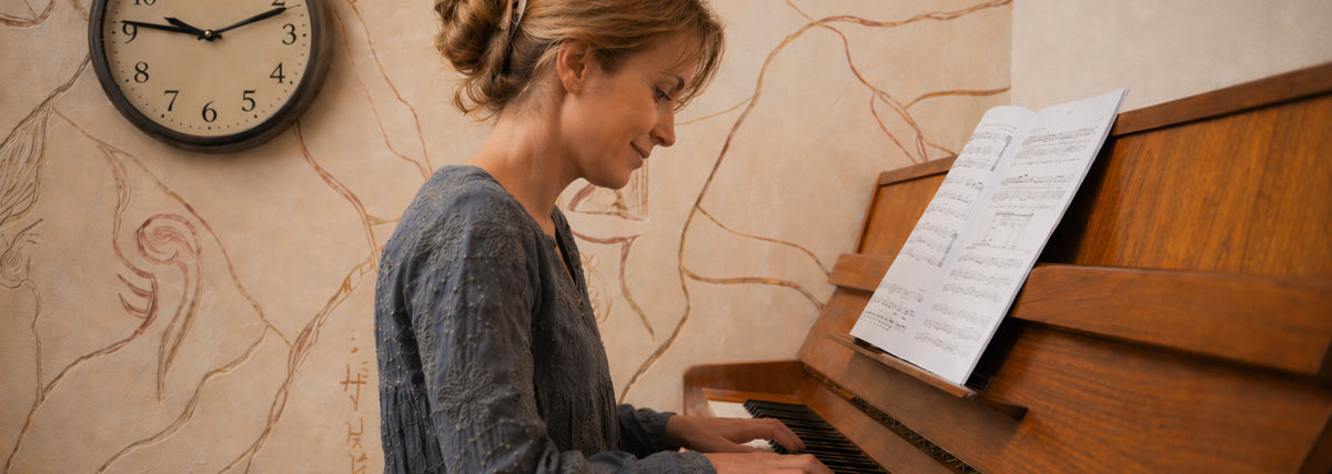 Frau spielt Klavier in einer Zimmerecke