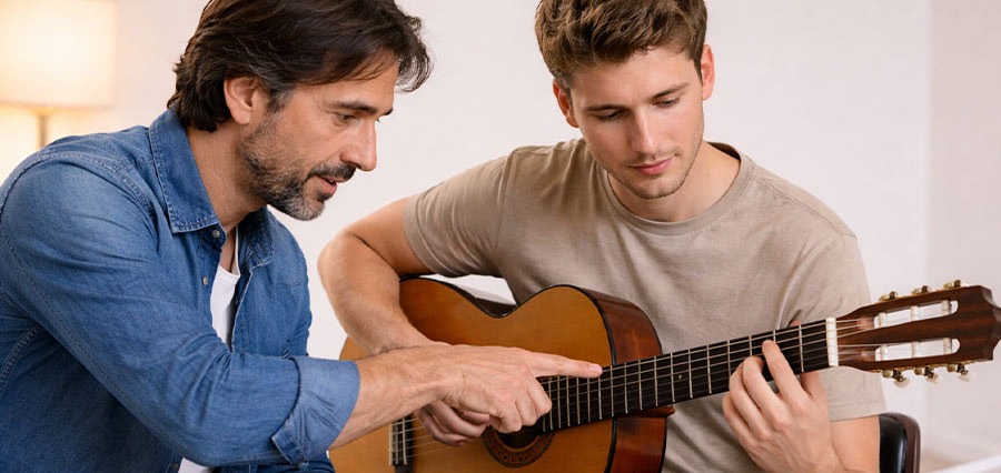 Gitarrenunterricht mit einem Lehrer und einem Schüler