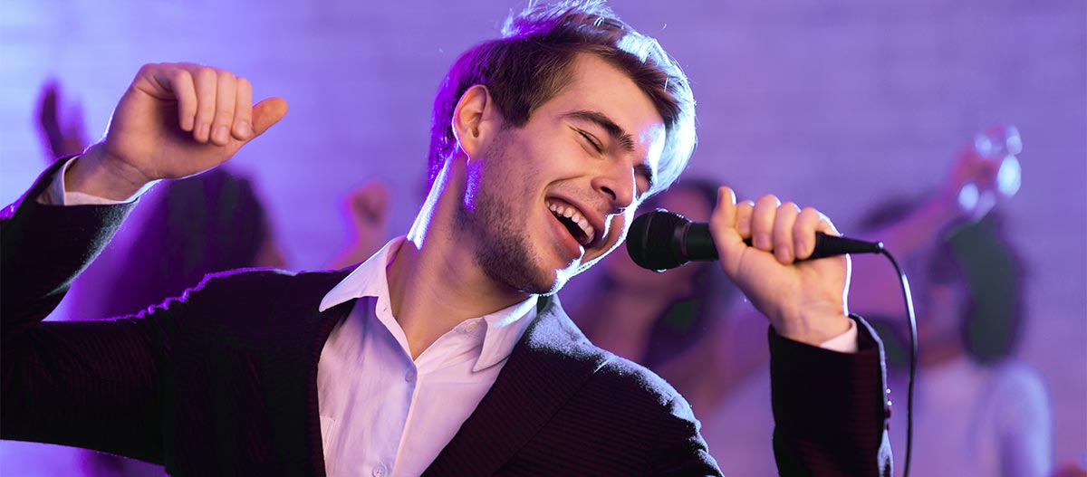 Junger erwachsener Mann der glücklich singt