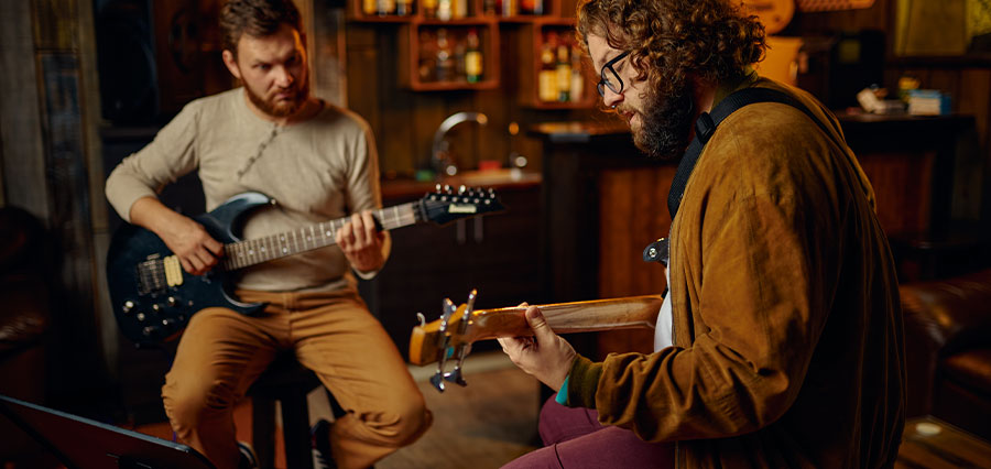 Two men playing electric guitar together