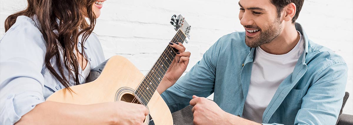 Frau spielt Gitarre für Mann