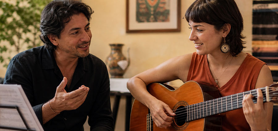 Lehrkraft und Schüler im Latin Gitarrenunterricht