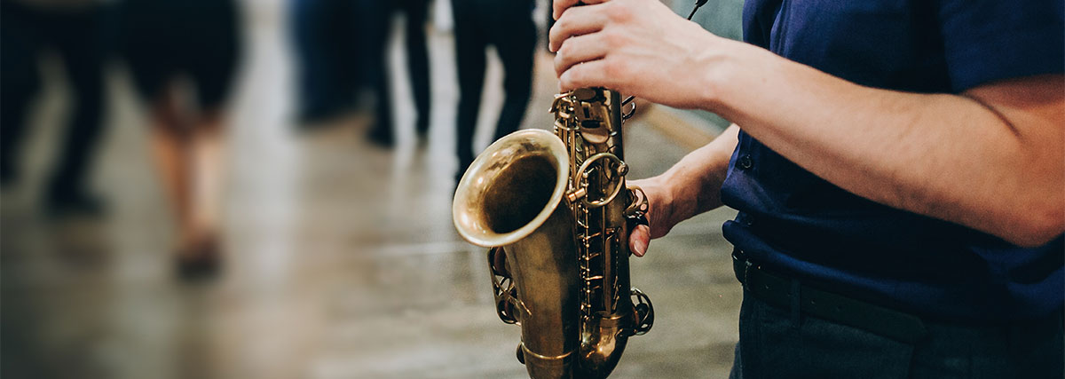 Männliche Hände halten ein Saxophon
