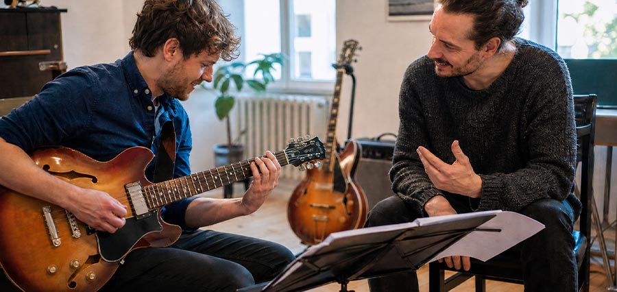 Schüler und Lehrer während einer improvisierten Gitarrenstunde