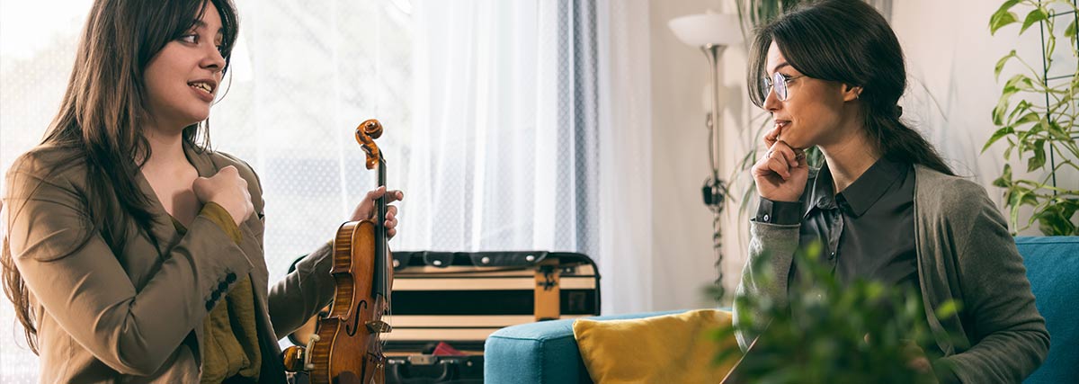Female violin teacher and student talking