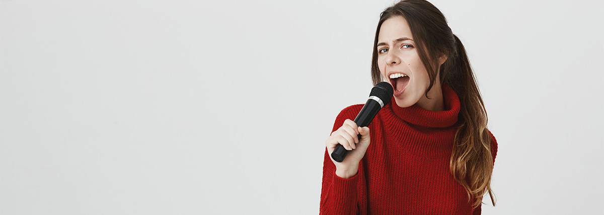 Eine Frau in einem roten Pullover singt