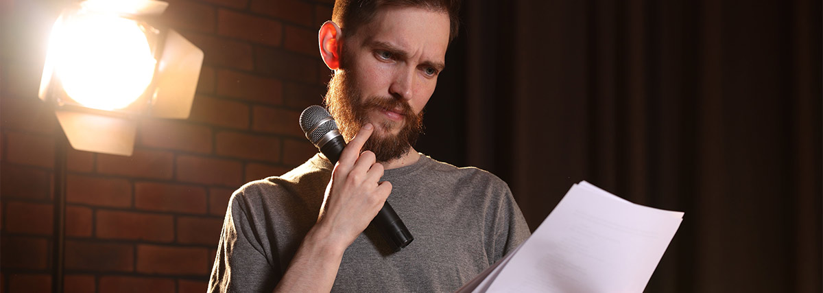 Man holding a sheet of music and a microphone