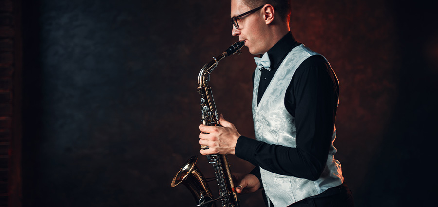 Saxophonist spielt ein Solo auf dem Tenorsaxophon vor dunklem Hintergrund